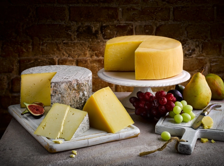 Une sélection de fromages avec des raisins et des figues.