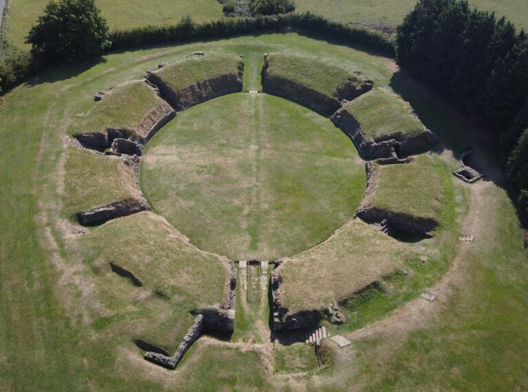An aerial view of a Roman amphitheatre in a green field