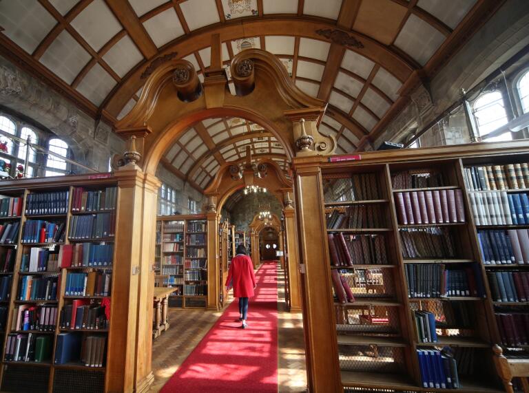 The inside of one of Bangor University's libraries with a very old wooden and ornate interior