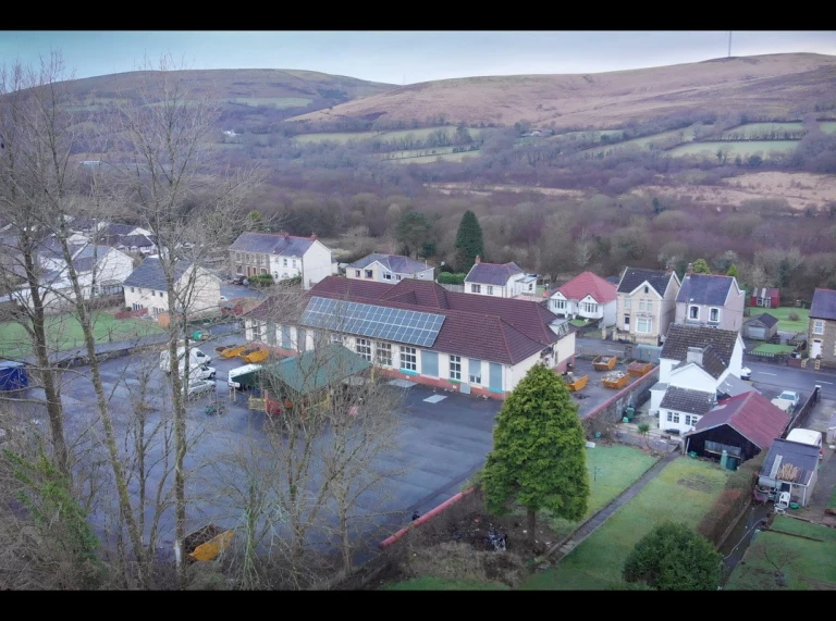 Photo aérienne au-dessus de Hwb y Gors/ancienne école primaire de Cwmgors – emplacement du terrain de jeux où un système de drainage durable sera construit, incluant des jardins pluviaux et un étang.