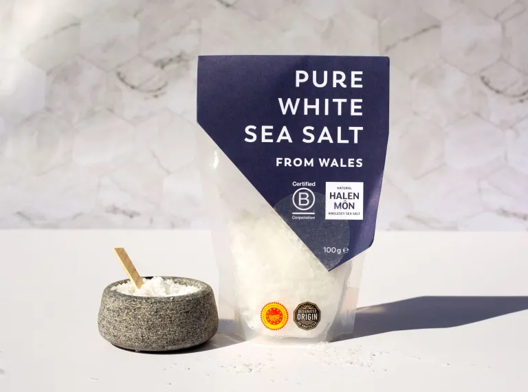 A packet of Halen Mon Pure White Sea Salt from Wales next to a small bowl with some loose salt in it