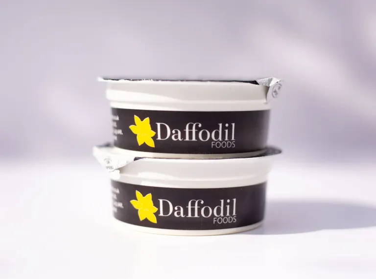 Two tubs of Daffodil Welsh Clotted Cream against a white background