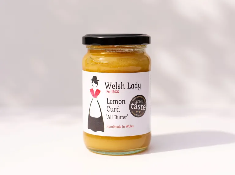 A jar of Welsh Lady Lemon Curd "All Butter" preserve against a white background