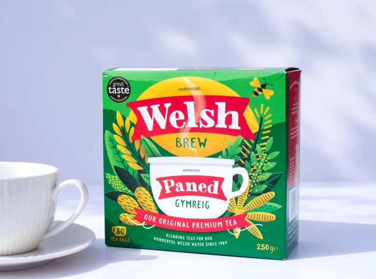A packet of Welsh Brew Tea next to a white teacup and saucer