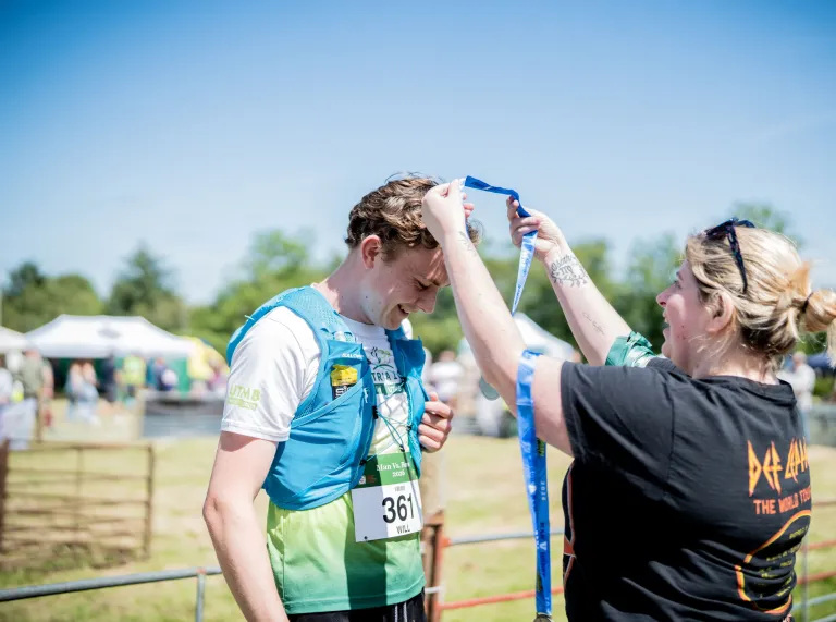 A runner receiving a medal at the end of the Man vs Horse race in Wales