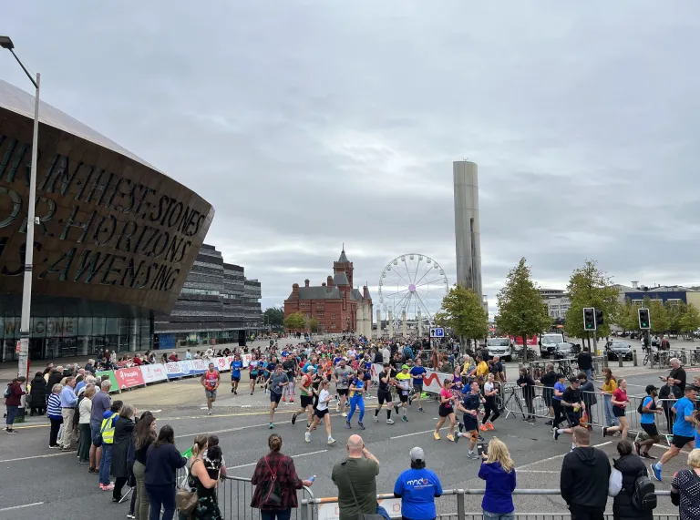 A group of marathon runners passing the Wales Millenium Centre in Cardiff