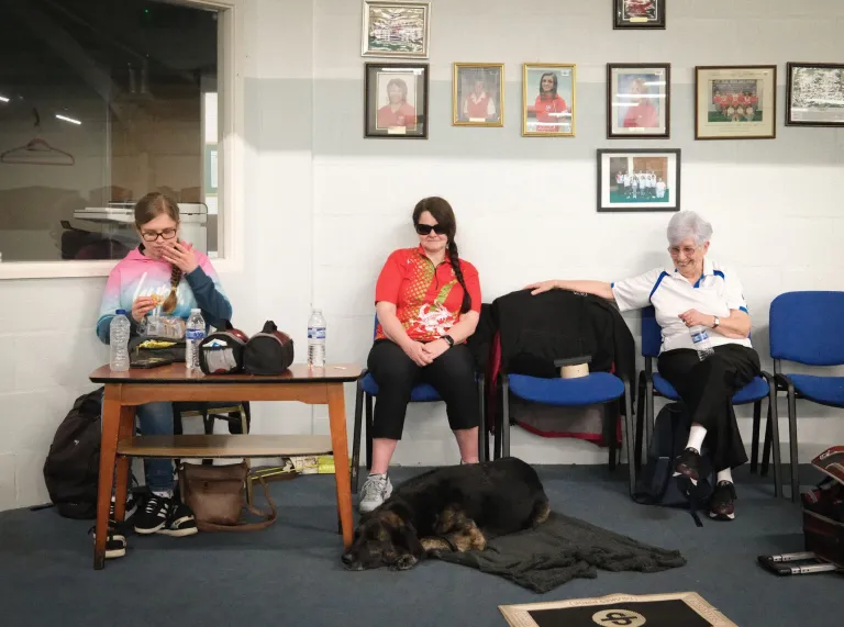 Julie Thomas relaxing with teammates and her guide dog between bowls matches.