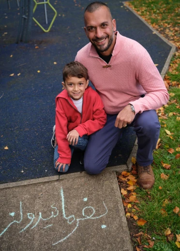 A father and son smiling at the camera