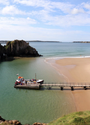 Sandy beach and the sea with a boat.