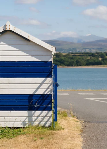 Blaue und weiße gestreifte Strandhütte an der Menai-Straße