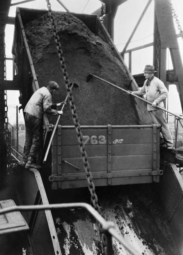 two men working with on coal truck.