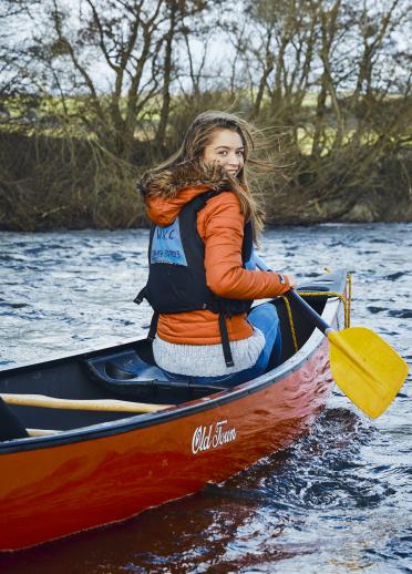 Eine junge Frau fährt Kanu auf dem Fluss Wye in Südwales.