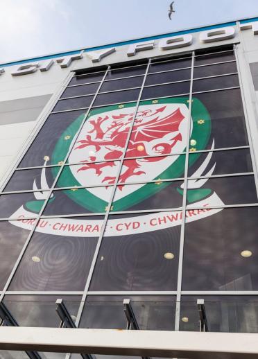 The Wales National football team crest with its motto ‘Gorau Cwarae Cyd Chwarae’ in the windows of Cardiff City Stadium 