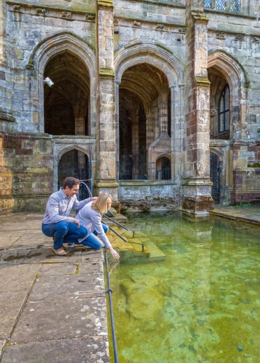 Dos personas metiendo sus manos en el agua.
