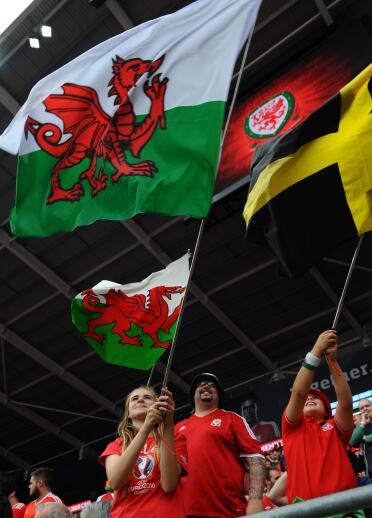 People holding the Welsh flag above their heads.