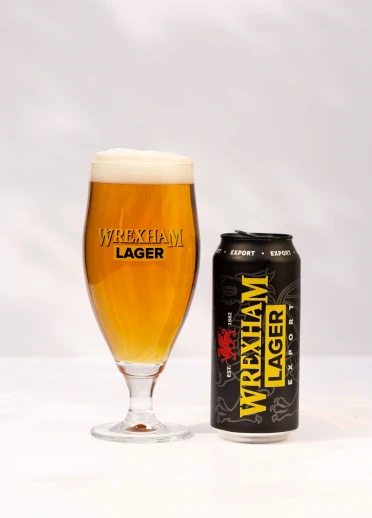 A poured glass of Wrexham Lager next to a can of Wrexham Lager Export