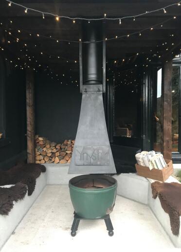 Eine Feuerstelle im Freien mit gestapeltem Holz.