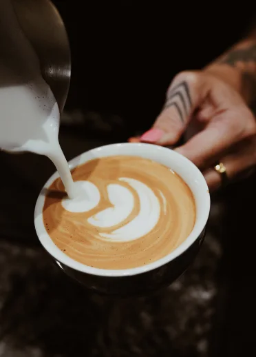 Milk being poured into a coffee cup.