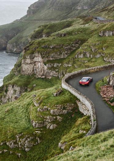 Aerial view of red Aston Martin driving through Great Orme, North Wales