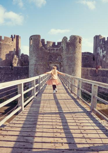 Castillo de Caerphilly, mujer caminando sobre puente