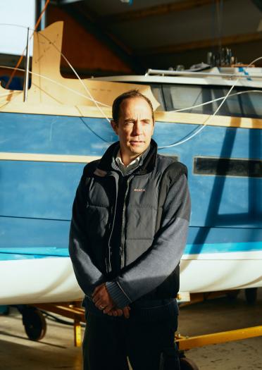 Porträt des Gründers von Schwalbenjachten vor dem Boot