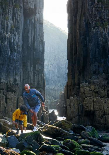 Padre e hijo explorando juntos en una playa rocosa