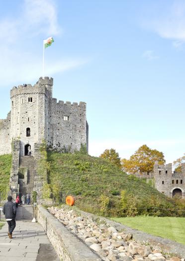 Exterior shot ofpeople walking towards the keep at Cardiff Castle.