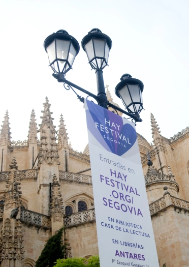 街灯に吊り下がったヘイ・フェスティバルのバナー。 背景に教会の建物がある。