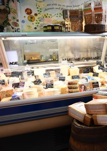 Interior shot of a cheese store with cheese behind the counter