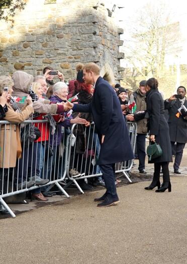 The Duke and Duchess of Sussex, Prince Harry and Meghan Markle greeting crowds behind barriers at Cardiff Castle