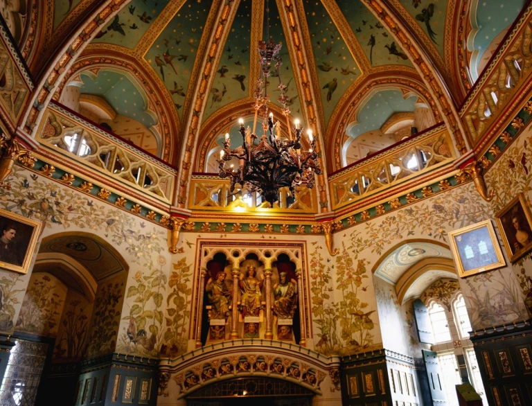 Un interior histórico ornamentado de un antiguo castillo, con un techo abovedado y una lámpara de araña.