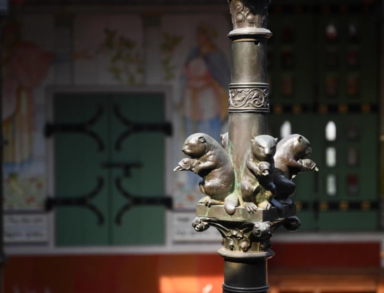 Detalle cercano de la metalistería de una nutria y un pato en un antiguo castillo.
