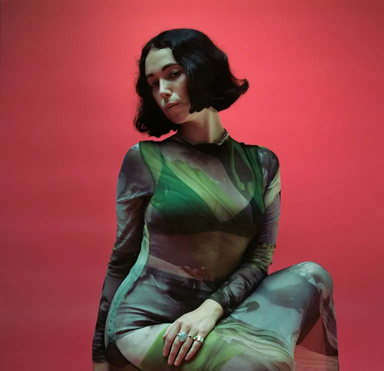 A woman in a green dress facing the camera