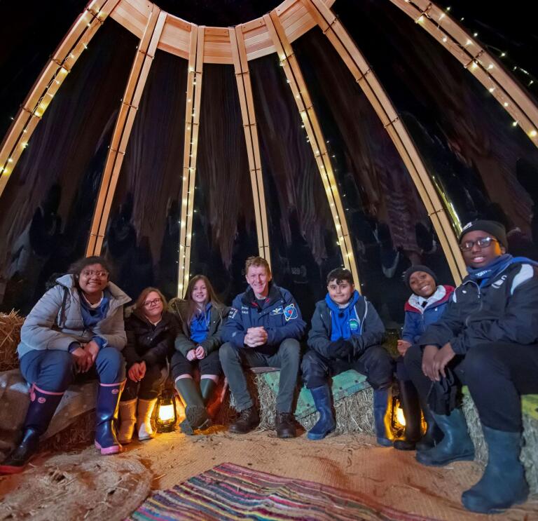 Eine Gruppe von Kindern sitzt in einem Zelt.