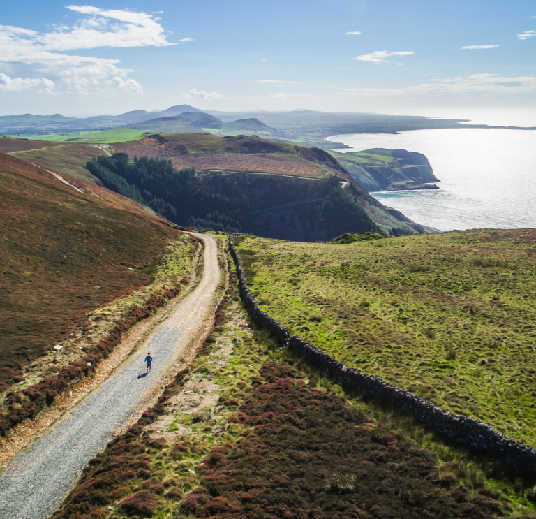 A road through the mountains with the sea in background.