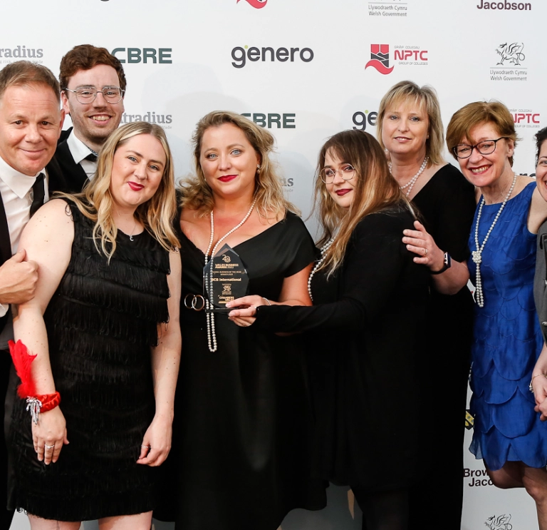 A group of people smiling and holding their award.
