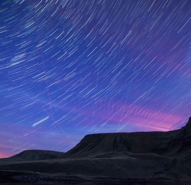 A dark night sky with stars showing brightly