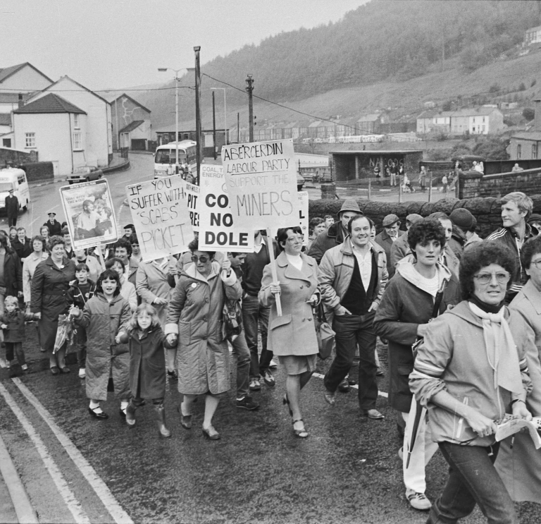 People walking down the street protesting.