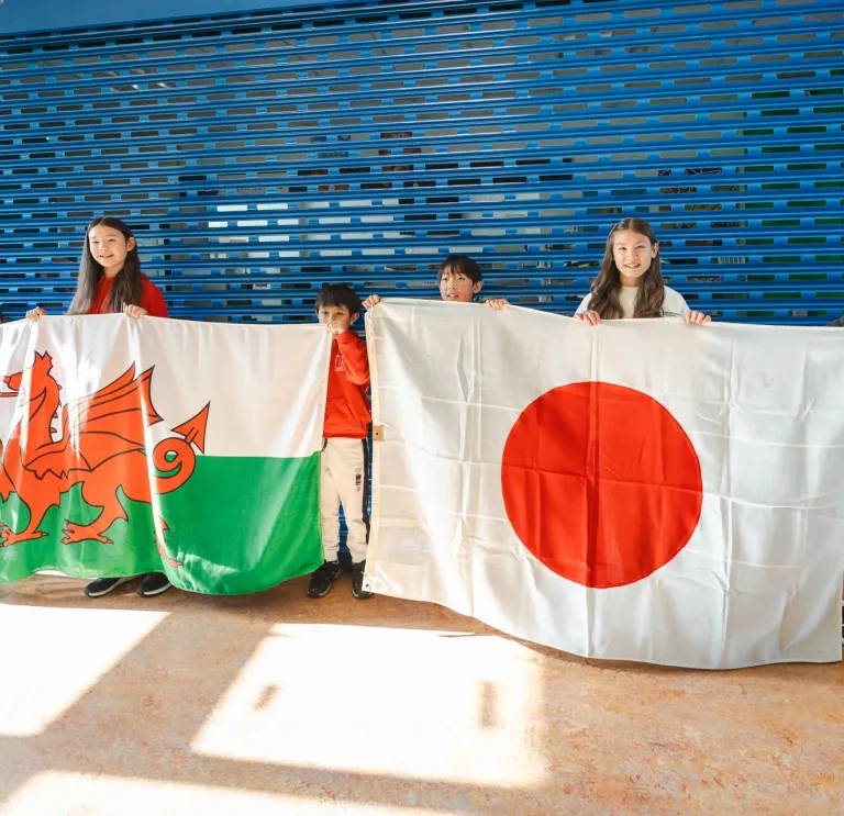 Children holding the Wales and Japan flags.