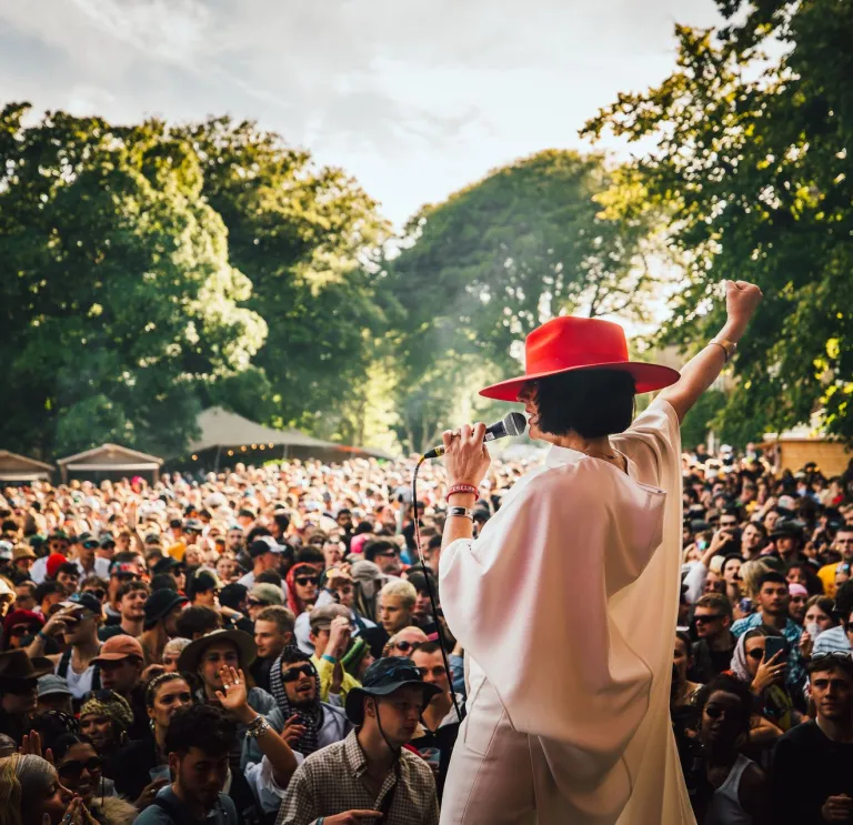 A singer on a stage in front of a crowd of people.