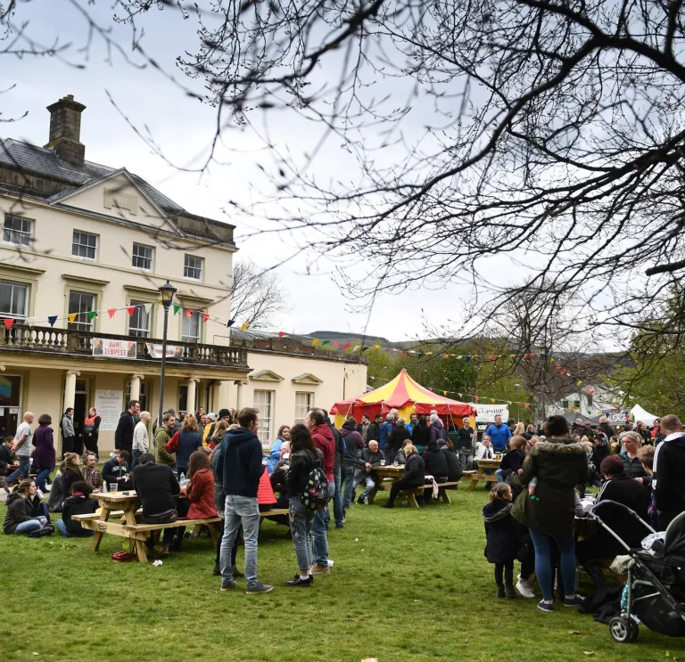 Crowds of people standing outside a large white building at the festival.