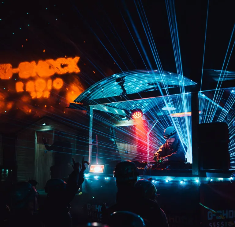 DJ Roni Size performing beneath blue laser lights at an underground rave in Cwmorthin Slate Mine, Eryri