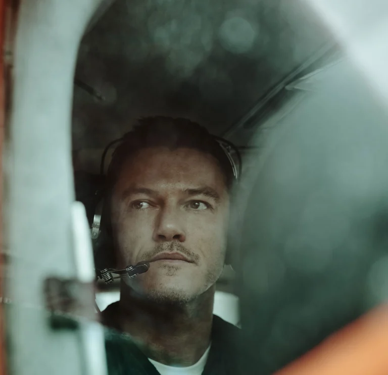 Luke Evans en pequeño avión con auriculares, listo para despegar