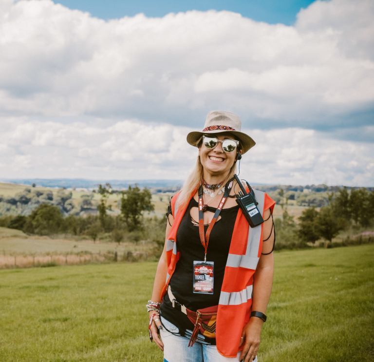 Sarah Price, mayordomo del Festival Steelhouse con el campo de fondo.