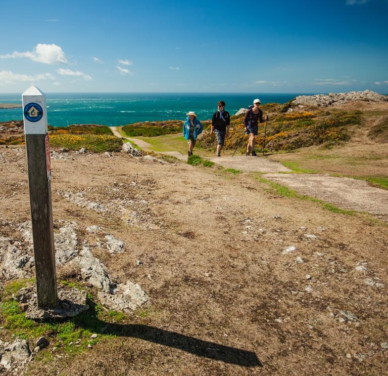 Wanderer auf dem Wales Coast Path mit dem Meer im Hintergrund.