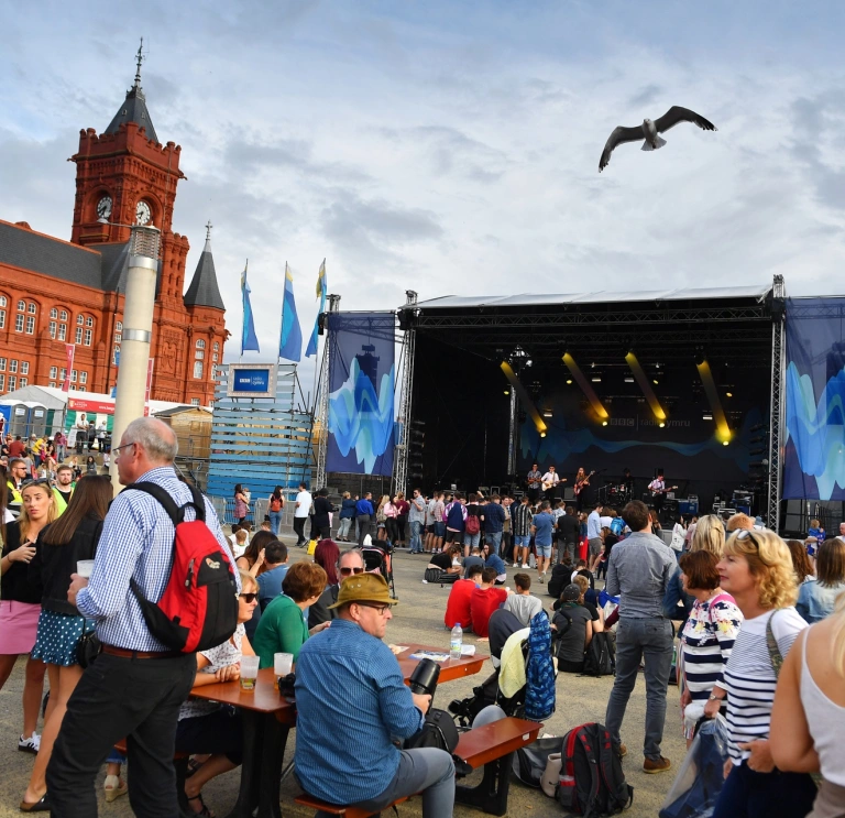 A band playing on a stage and a crowd watching them
