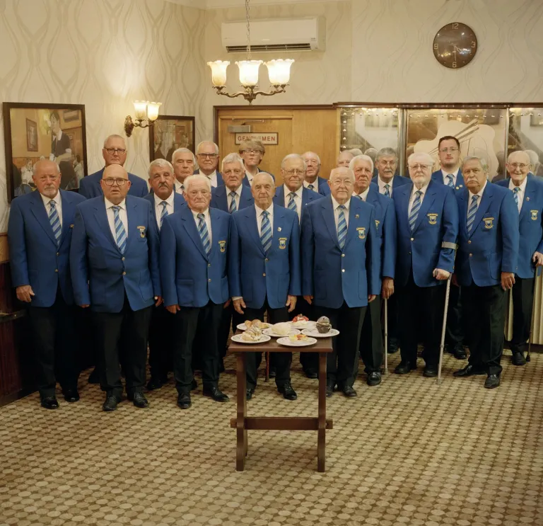 Coro de voces masculinas de Pontypridd de pie en un grupo.