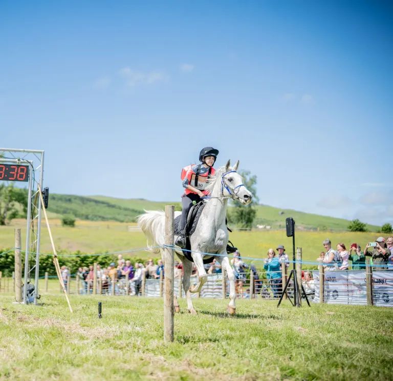 A rider on horseback reaching the end of the Man vs Horse race in Wales