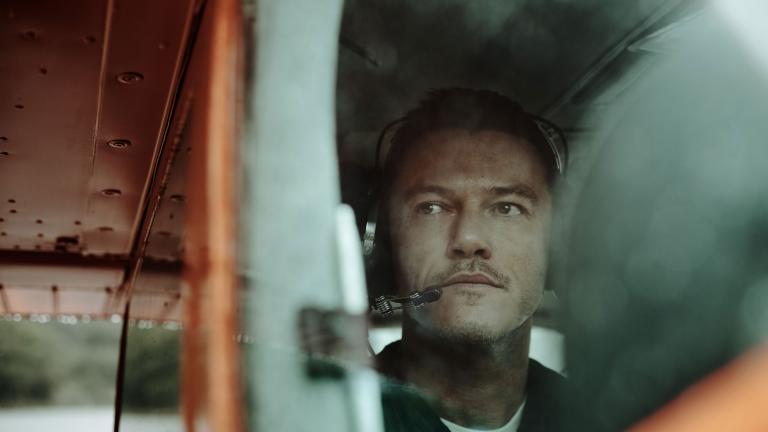 Luke Evans in small plane with headset, ready for takeoff