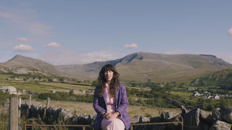 Lisa Jen sitting on a wall in Snowdonia.